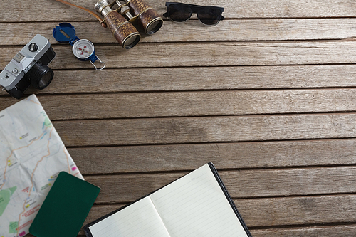 Overhead of travelling accessories on wooden plank