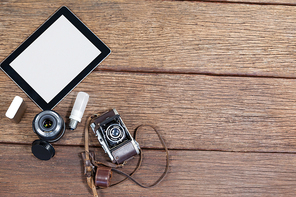 Close-up of old fashioned camera, lens, bulb, digital tablet on table in studio