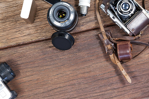 Close-up of old fashioned cameras, lens, bulb on table in studio