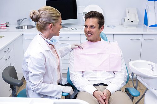 Happy patient looking at dentist at medical clinic