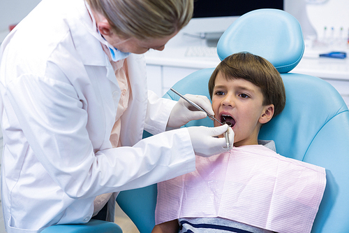 Boy receiving dental treatment by dentist at medical clinic