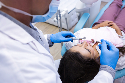 Close up of dentist examining woman mouth at medical clinic