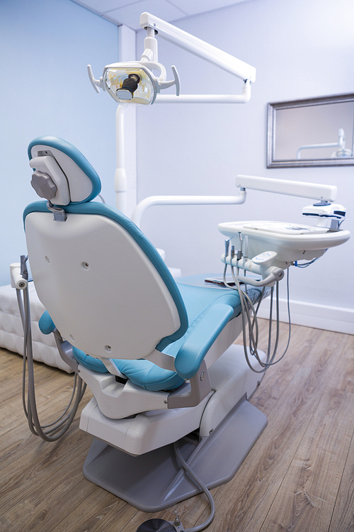 Low angle view of dentist chair with medical equipment in clinic
