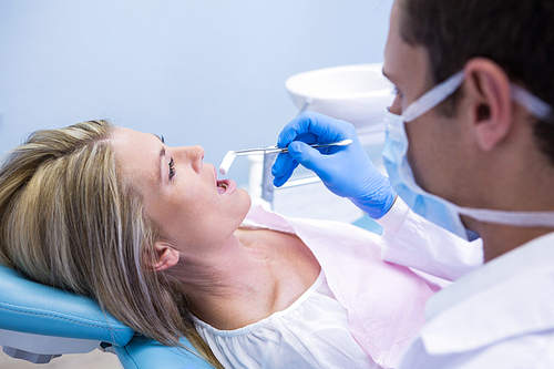 Close up of dentist examining woman at dental clinic