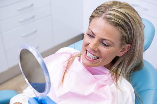 Close up of woman looking at mirror in dental clinic