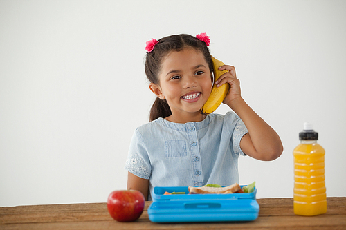 Adorable schoolgirl having breakfast against white background