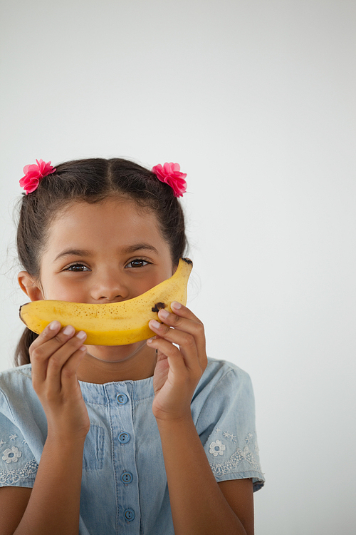 Adorable schoolgirl having breakfast against white background