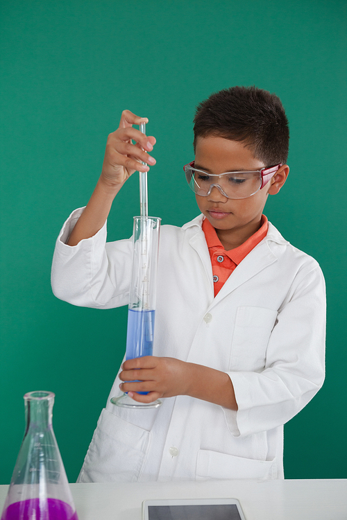 Attentive schoolboy doing a chemical experiment in laboratory at school