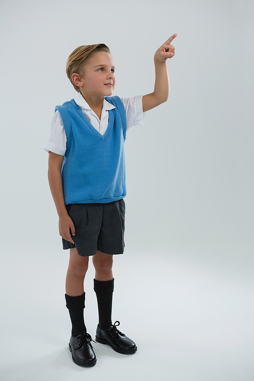 Close-up of schoolboy pointing finger against white background