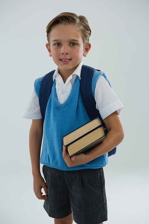 Portrait of happy schoolboy holding books