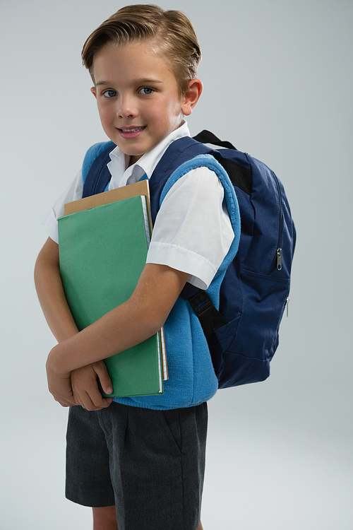 Portrait of happy schoolboy holding books