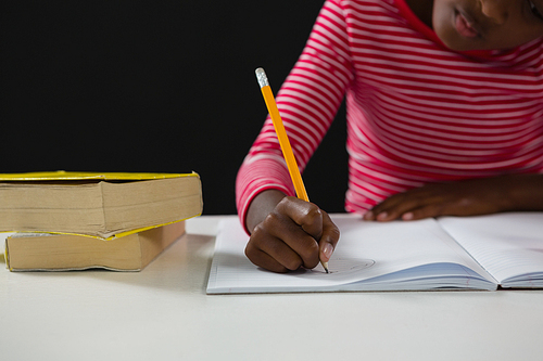 Mid section of schoolgirl doing homework