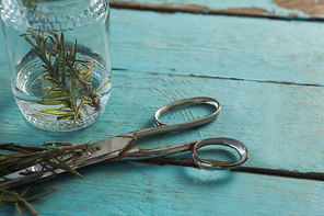 Close-up of rosemary and scissors on wooden table