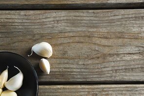 Overhead of garlics in plate on wooden table