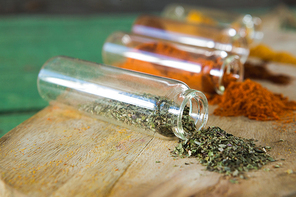 Close-up of various spices spilling out of bottles