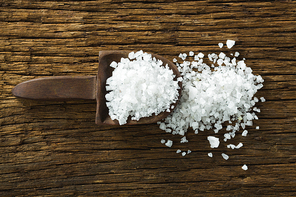 Close-up of salt in spoon on wooden table