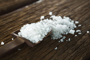 Close-up of salt in spoon on wooden table