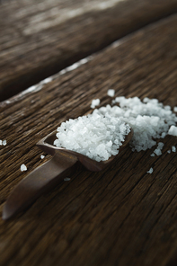 Close-up of salt in spoon on wooden table