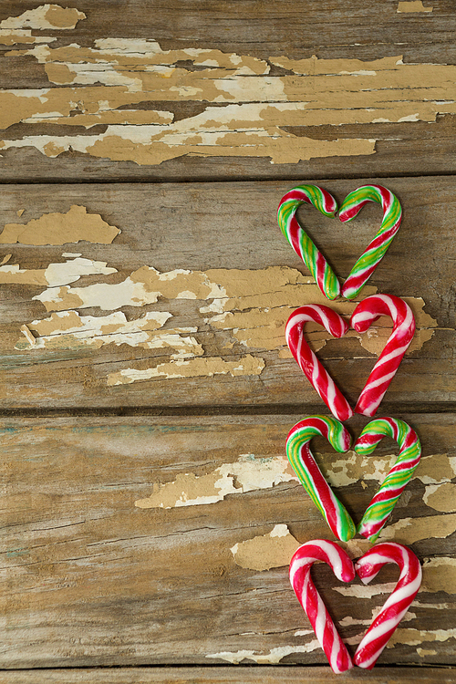 Close-up of multicolored candy canes arranged on wooden plank