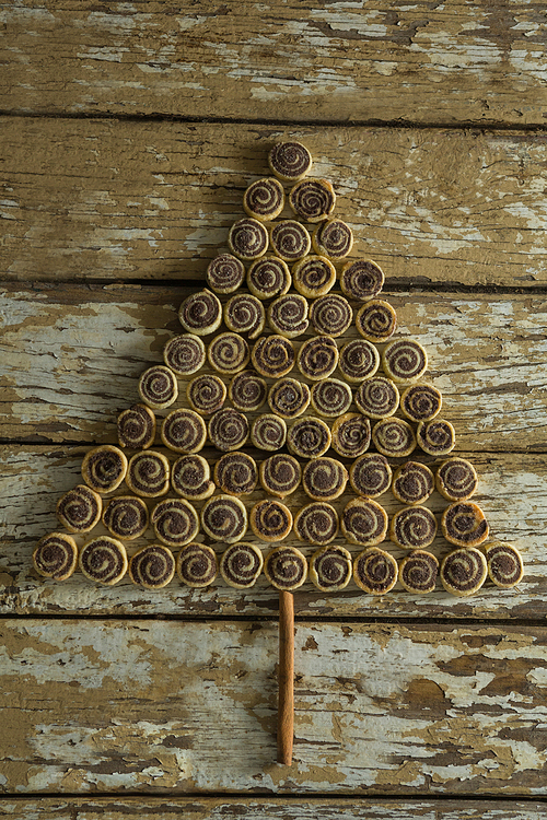 Chocolate cookies arranged in christmas tree shape on wooden plank