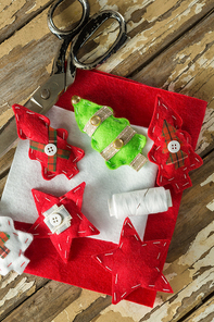 Close-up of handmade christmas trees and craft material on wooden plank