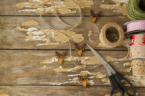 Ribbon roll, scissors and jute rope on wooden table during christmas time