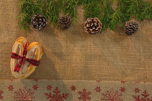 Overhead view of food tied with ribbon by pine cone and twigs on burlap