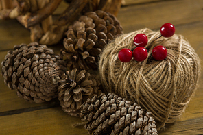 High angle view of pine cones with thread spool with push pin on table