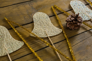 High agnle view of glittering sticks and bell shape decoration on wooden table