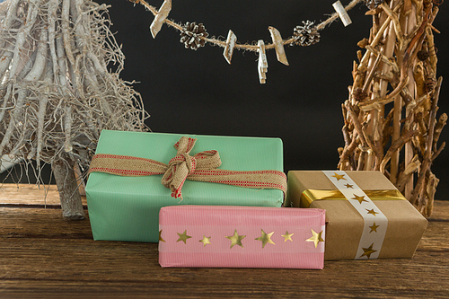 Close up of gift boxes with Christmas decoration on table against black background