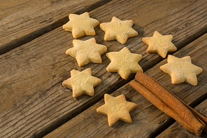 Close up of Christmas tree made with star shape cookie and cinnamon stick on wooden table