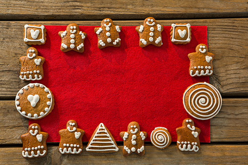 Overhead view of gingerbread cookies arranged on red fabric at table