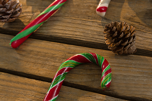 Close up of candy canes and pine cones on wooden table