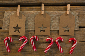High angle view of star shape decoration with burlap and clothespin by candy canes on table