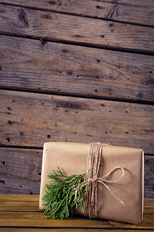 Close-up of gift box, fir and pine cone on wooden table
