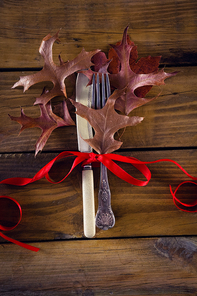 Close-up of tied knife and fork on wooden table