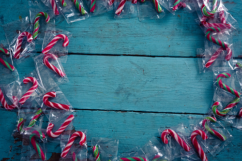 Overhead of candy canes forming circle on wooden plank