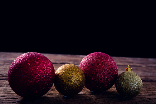 Close-up of christmas baubles on wooden plank