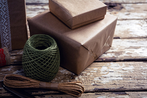 Close-up of gift boxes with wrapping material on wooden plank