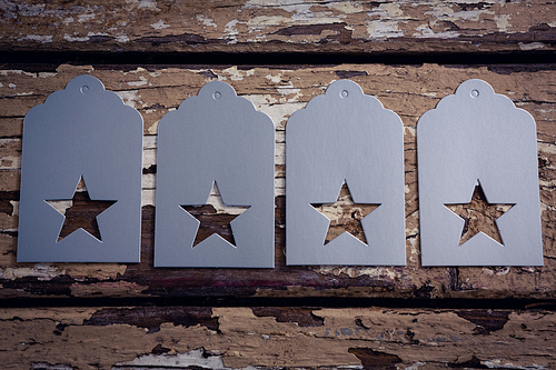 Close-up of tags with star shape on wooden plank