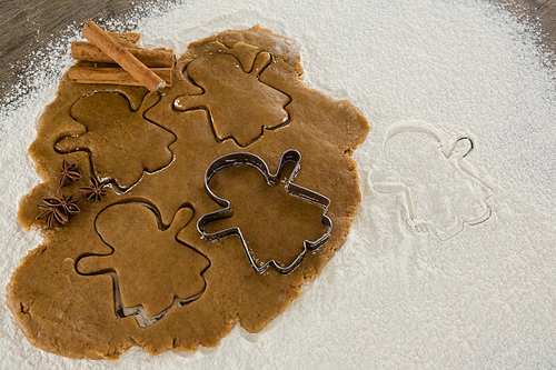 Gingerbread dough with flour, cookie cutter, anise and cinnamon on wooden table