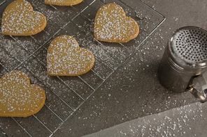 Close-up of raw heart shape cookies with sugar icing on baking tray