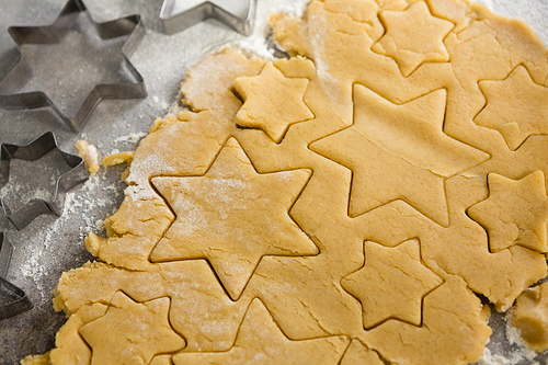 Close-up of raw cookie dough with star shape and cutter
