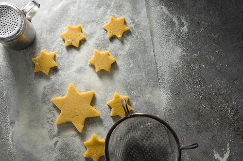 Close-up of star shape cookies on flour with strainer