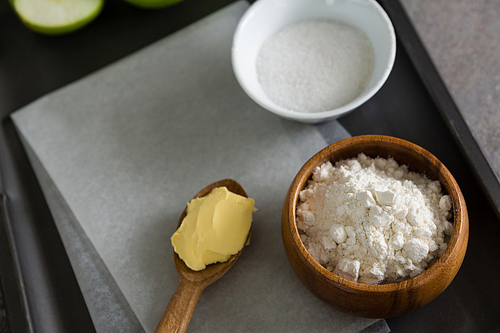 Close-up of sugar bowl and flour with butter in spoon