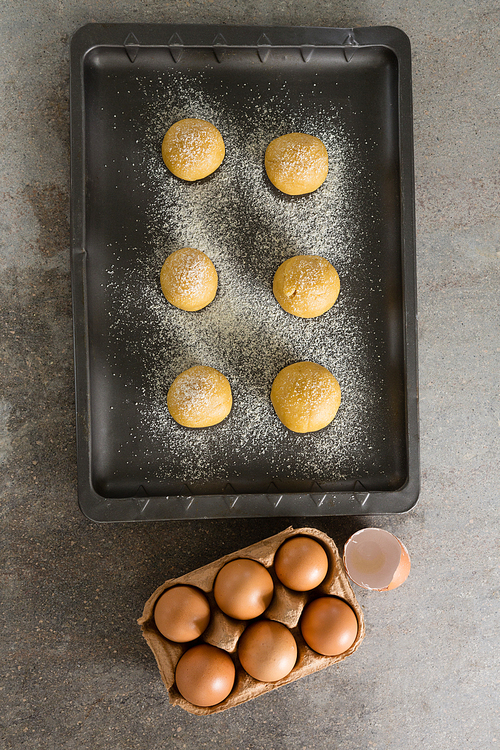 Overhead of dough balls with icing sugar on baking tray