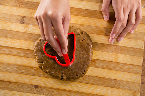 Mid-section of man molding gingerbread dough on wooden board