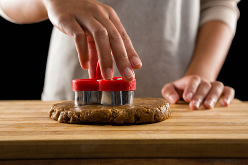 Mid-section of man molding gingerbread dough on wooden board