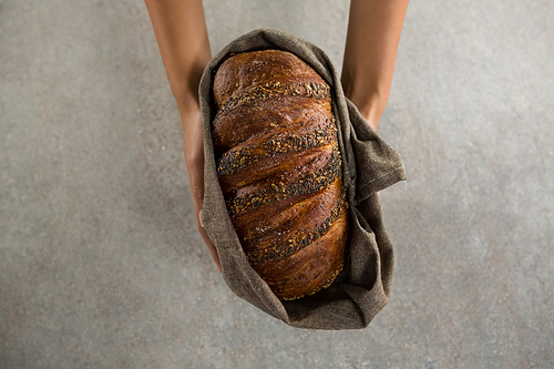 Close-up of woman holding a loaf of bread