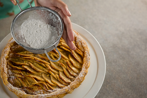 Close-up of woman icing on apple tart